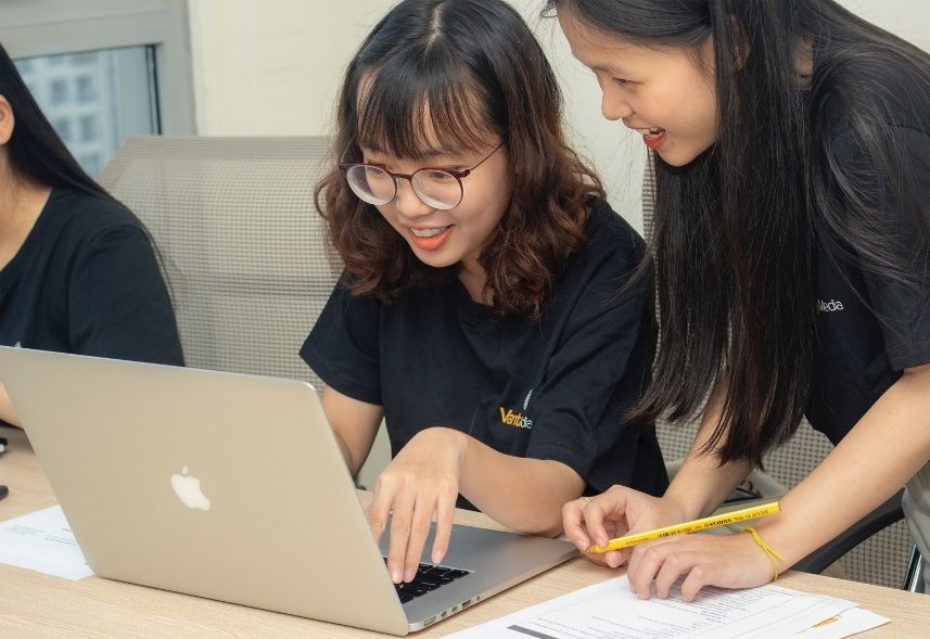 analista de midias sociais: imagem de duas meninas olhando para a tela de um notebook conversando entre si