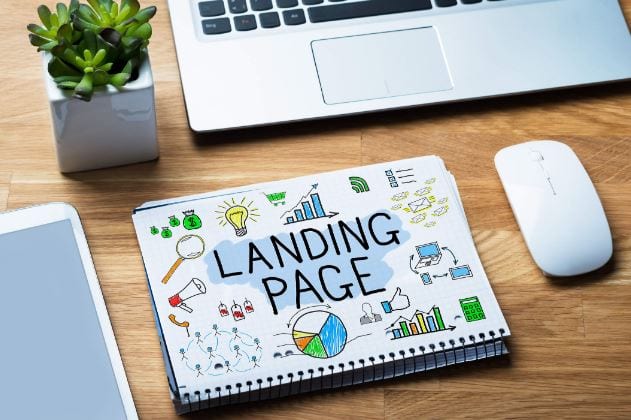 Como criar uma landing page: imagem de um caderno e um notebook em cima da mesa.