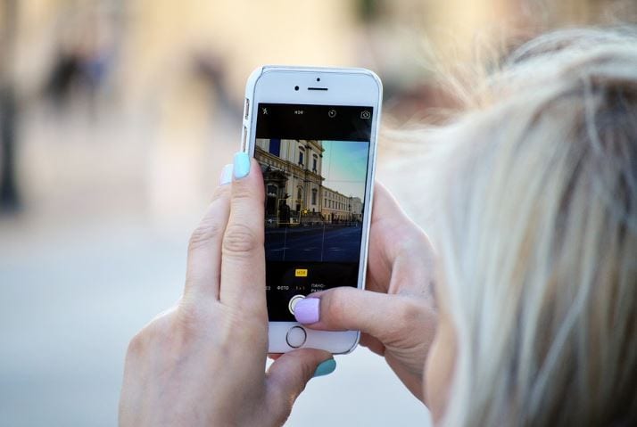 Stories Ads: imagem de uma mulher segurando um celular com a tela dos Stories aberta para gravar um vídeo