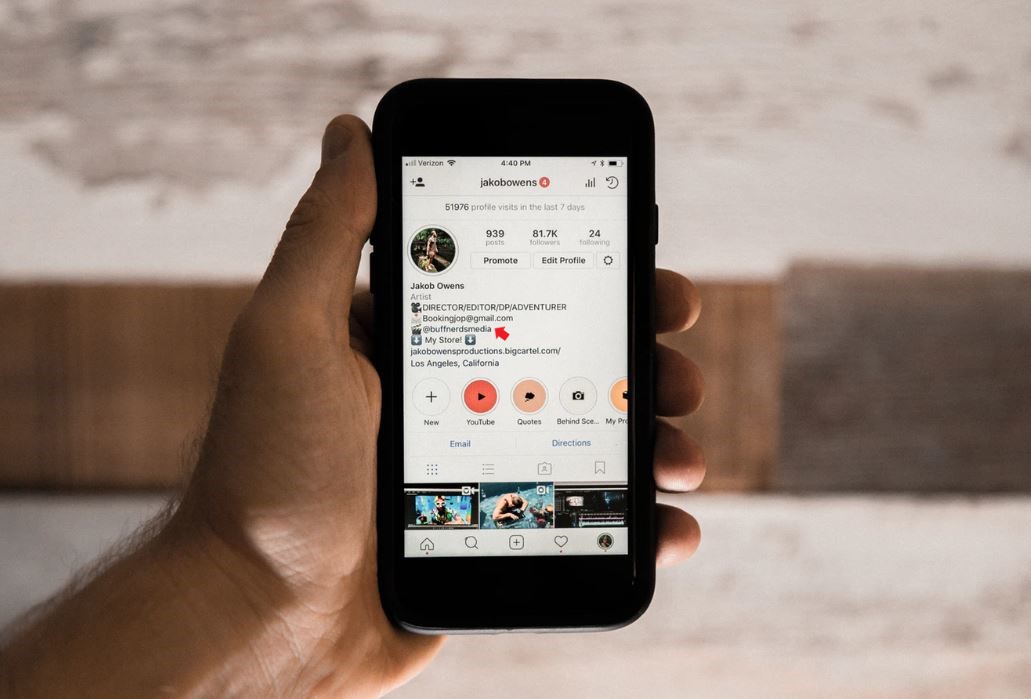 Link na Bio: imagem de uma mão segurando um celular com a página de um perfil do instagram na tela
