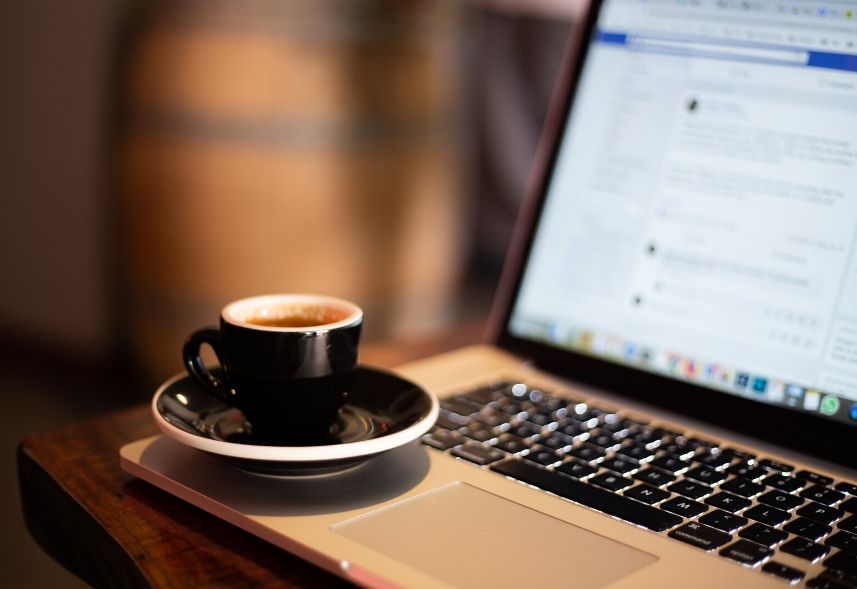 Ultimas novidades do Facebook: imagem de um notebook aberto com a página do Facebook na tela e uma xícara de café