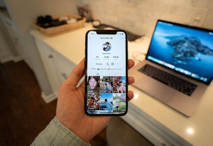 TikTok Marketing: imagem de uma mão de homem segurando um celular com a tela aberta no TikTok