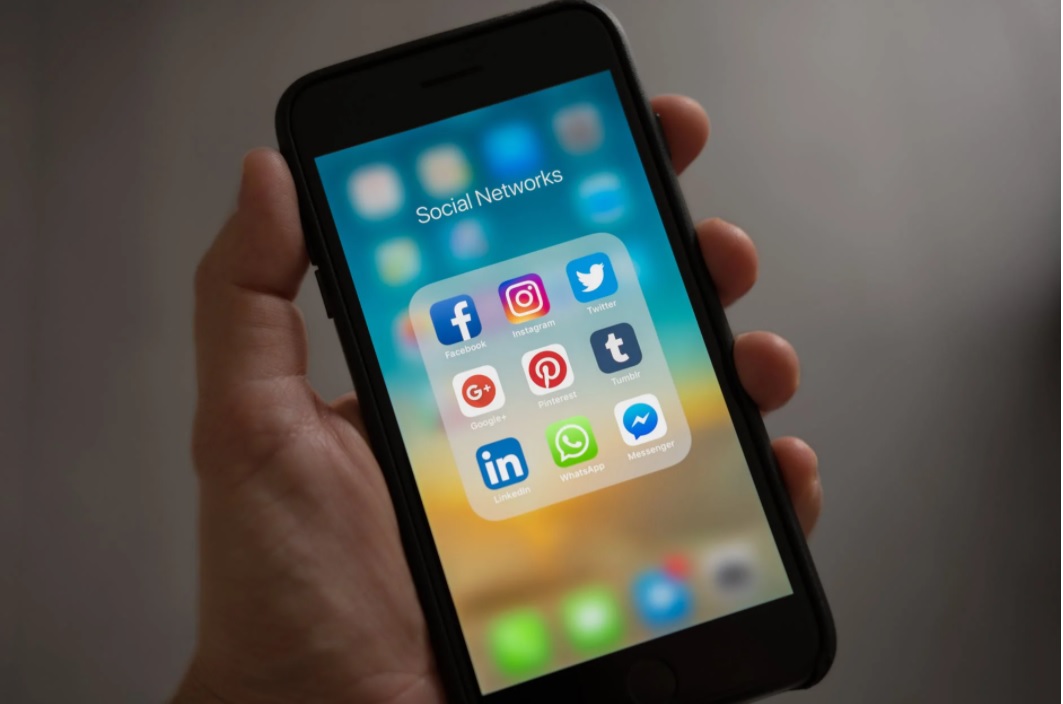mobile first: uma mão segura um celular e dentro da tela é possível ver atalhos de aplicativos de redes sociais como Facebook, Instagram, Twitter e tumblr.