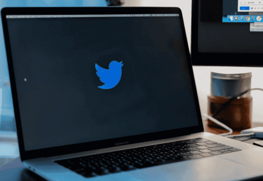 Como usar Twitter: a imagem é de um computador que está ligado, a tela está toda preta apenas com o logo do Twitter no centro, um pássaro azul.